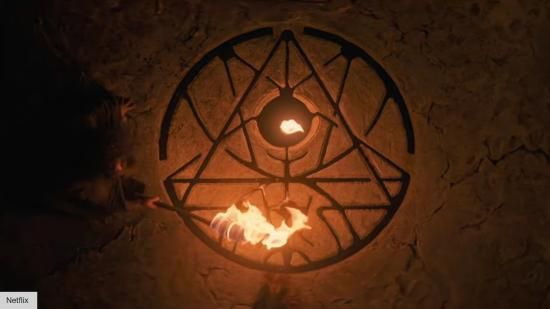 Кружни симбол црне магије, урезан у земљу и испуњен крвљу, видљив на светлости ватре